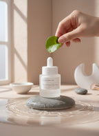 Ampolla iluminadora K-Chic Skin Especialidad con niacinamida y centella asiática sobre piedra en entorno natural