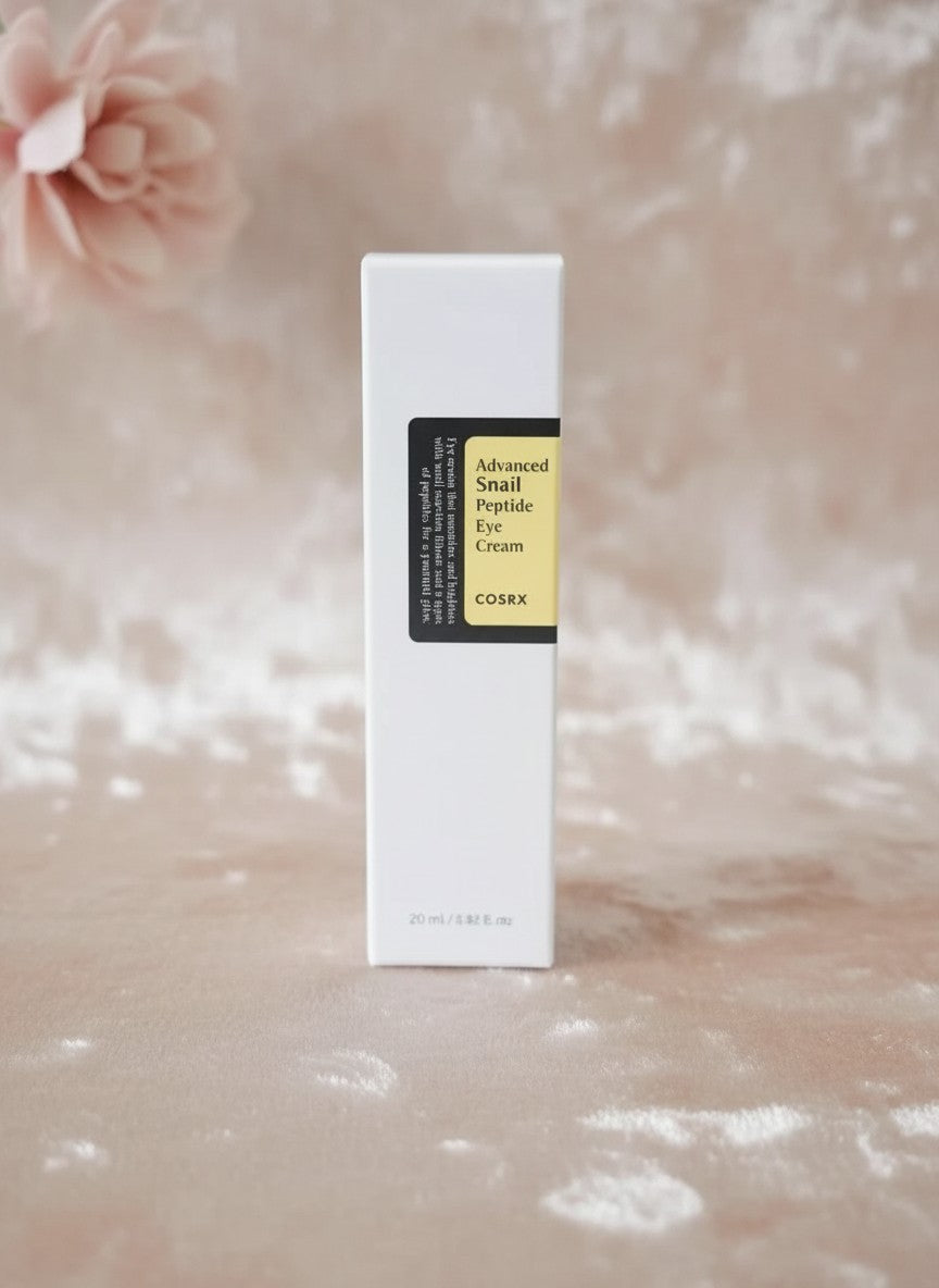 Envase de COSRX Advanced Snail Peptide Eye Cream de K-Chic Skin Especialidad sobre fondo suave y elegante