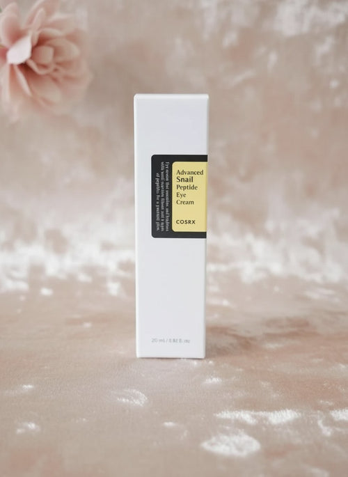 Envase de COSRX Advanced Snail Peptide Eye Cream de K-Chic Skin Especialidad sobre fondo suave y elegante